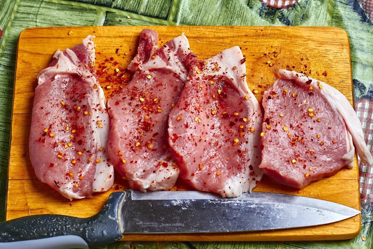 Seasoned and Sliced Pork Chops on the Chopping Board