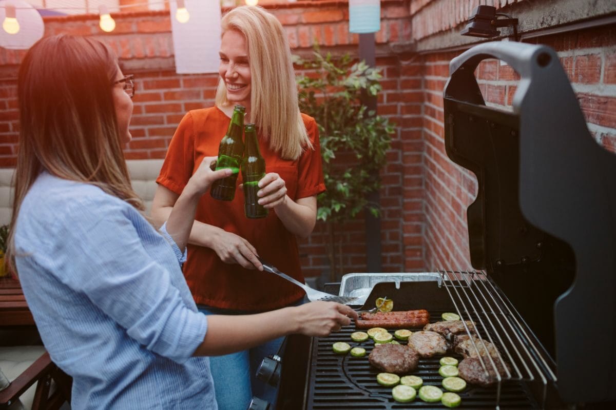 Two Women Chatting and Grilling Meat
