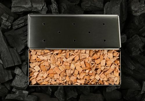 Metal Smoker Box with Wood Chips on Charcoal