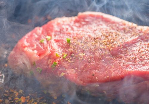 Sizzling New York Steak On Hot Cast Iron Pan