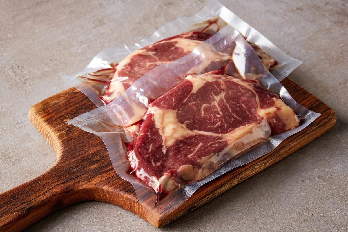 Vacuum Sealed Beef Steak Packs on Wooden Board