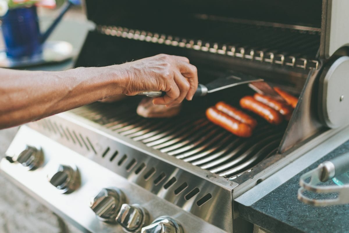 Man Grilling Sausages on the Grill