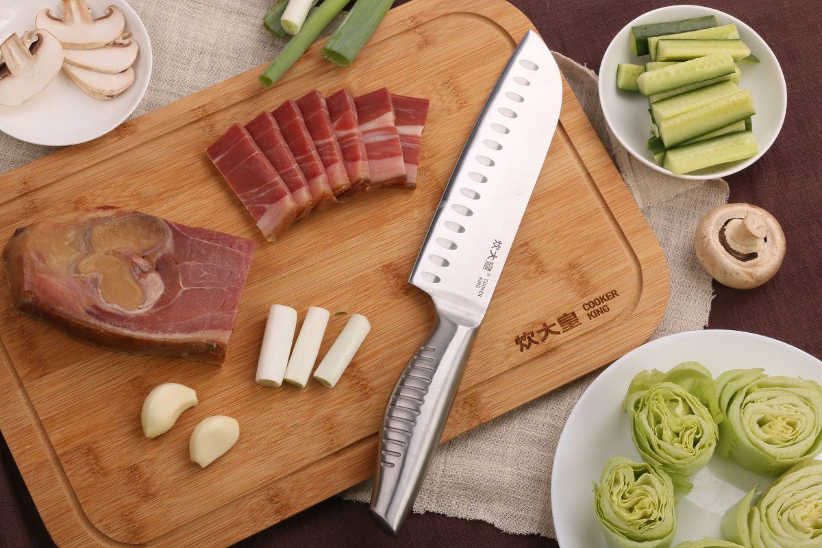 Sliced Meat and Veggies Along with a Silver Knife