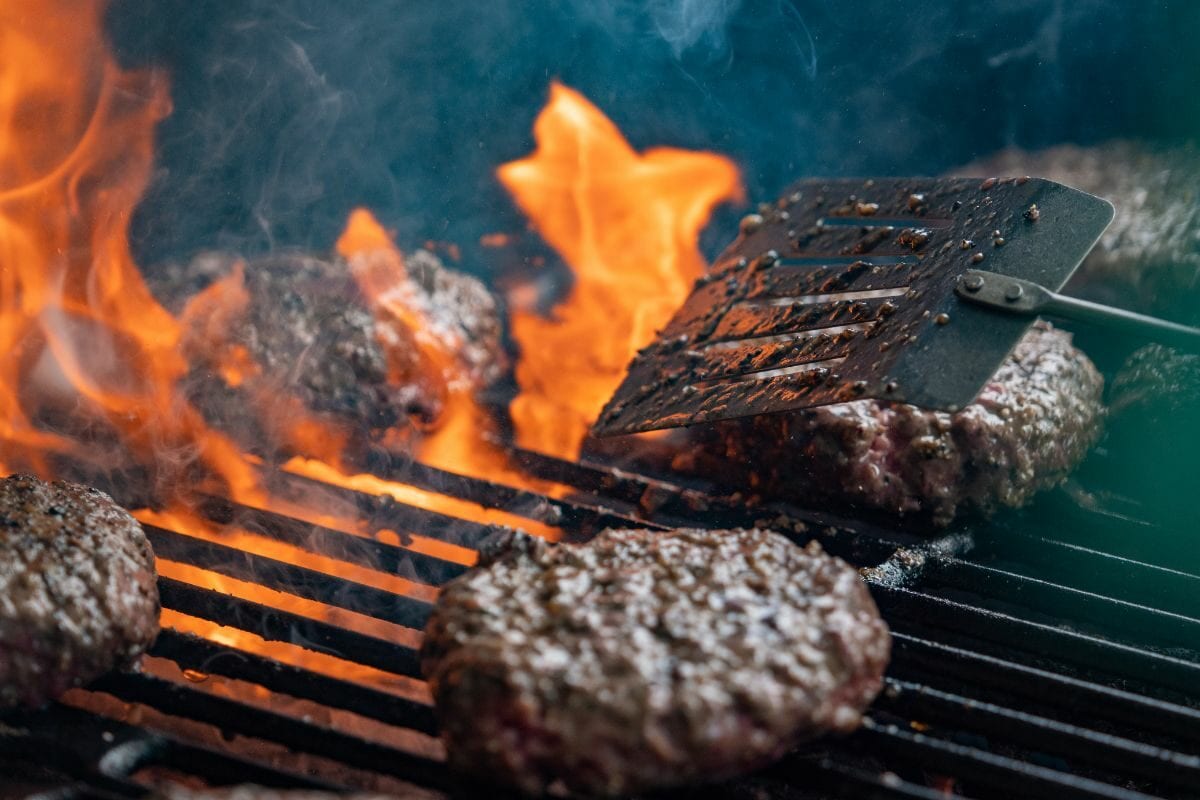 Burgers Cooking on an Open Flame Grill Top