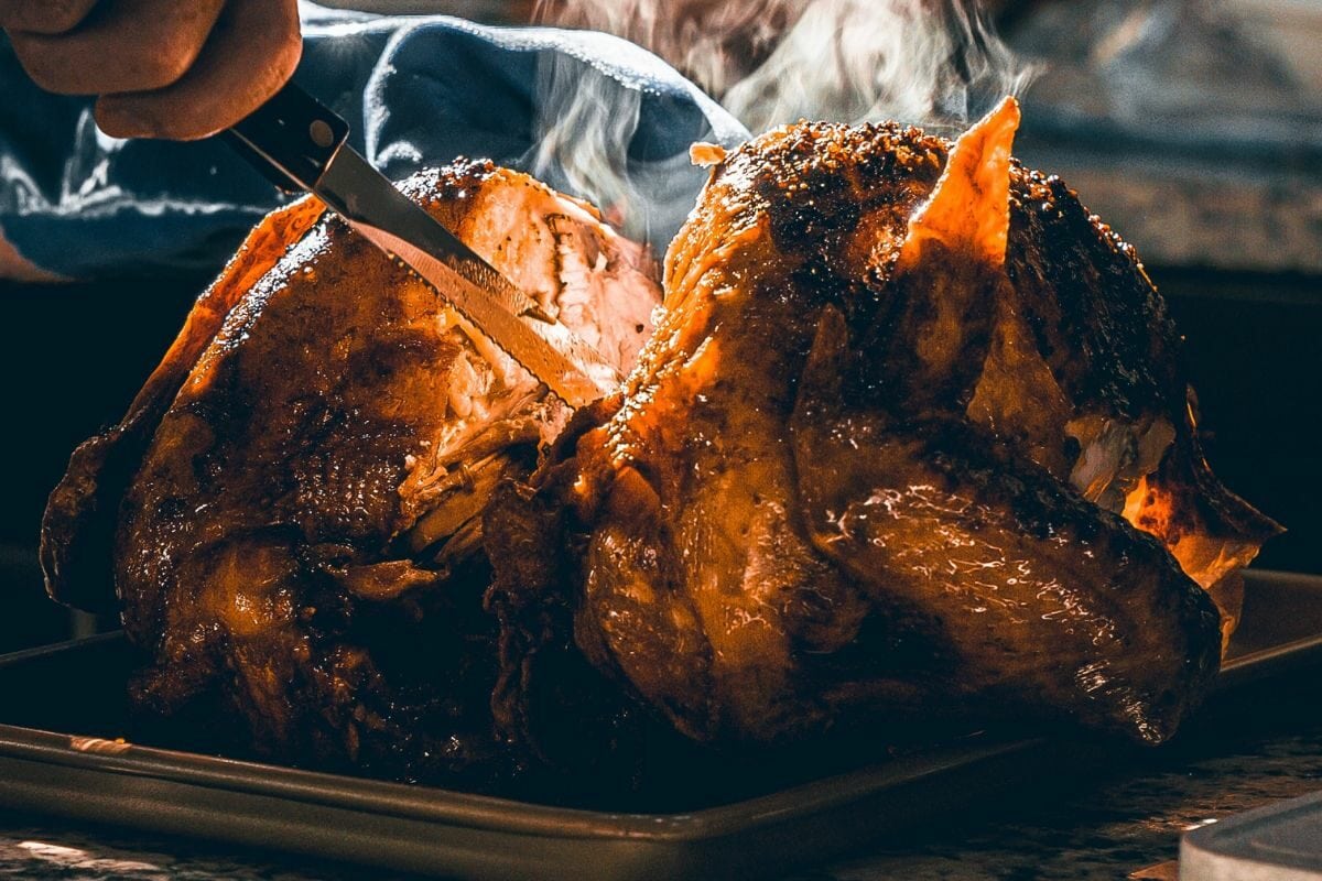 Person Slicing Sizzling Hot Grilled Turkey