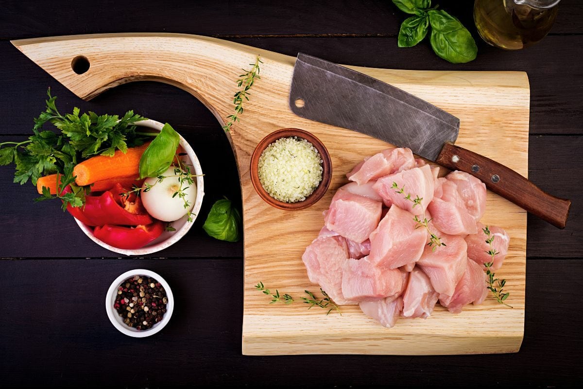 Raw Chicken Fillets and Knife on the Wooden Board