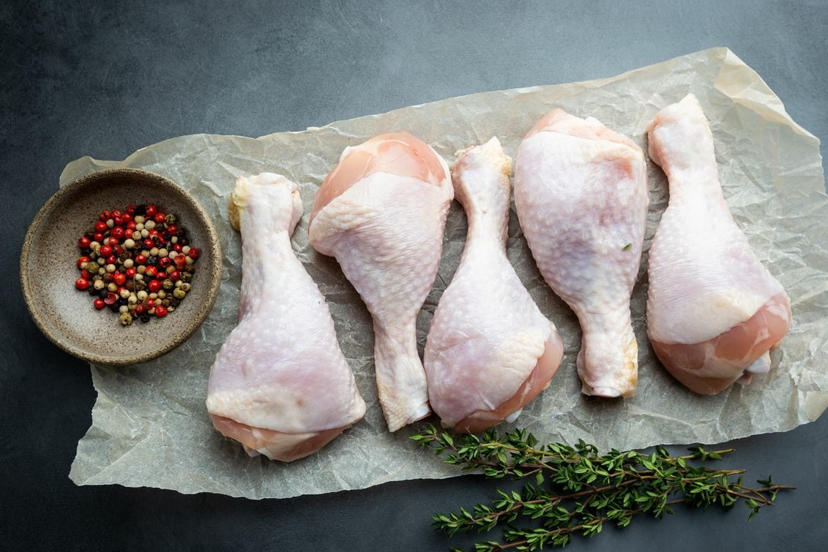 Raw Chicken Drumsticks with Herbs and Leaves