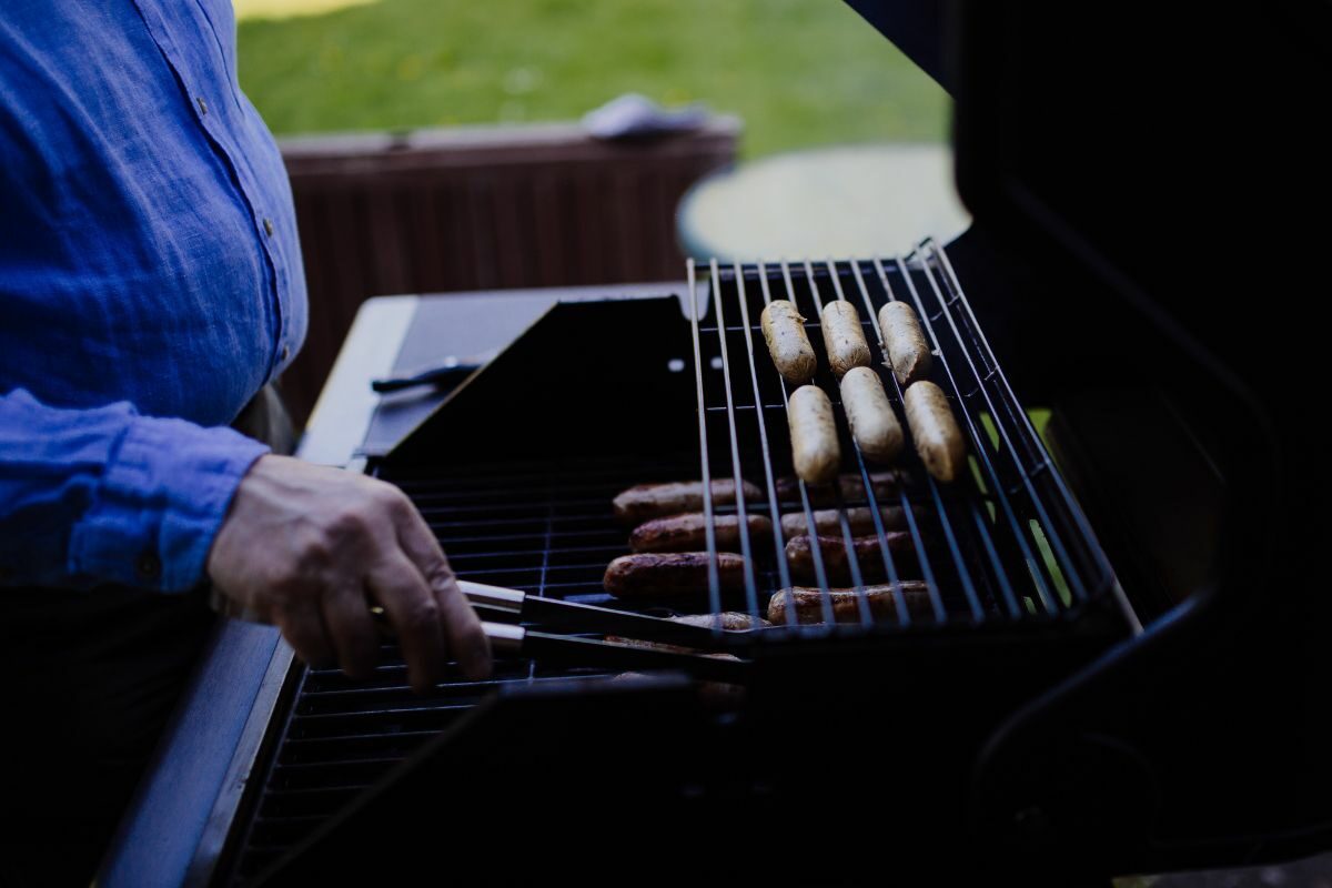 Man Grilling Sausages on the Portable Grill