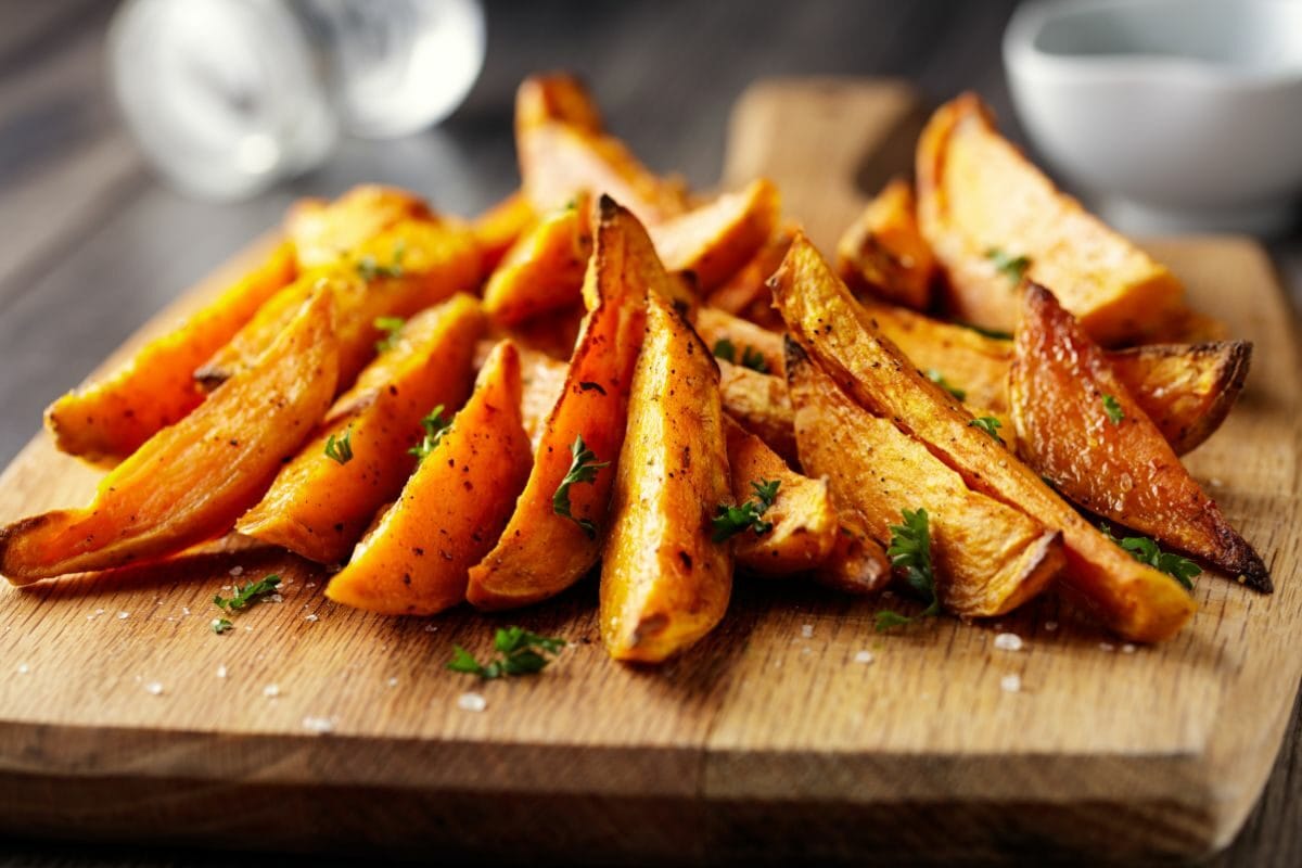 Roasted Sweet Potatoes Wedges on the Wooden Board