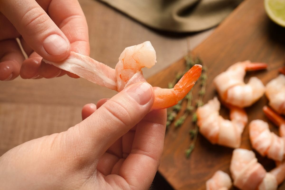 Woman Wrapping Bacon in Shrimp Slices